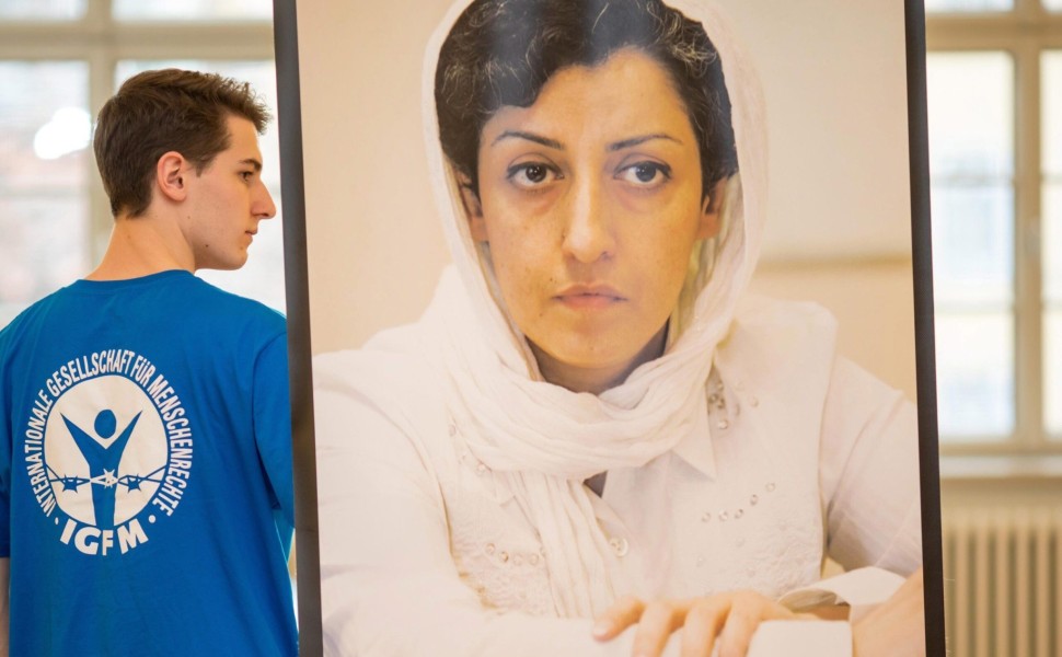 epa05669066 A man carrying a picture of award winner Narges Mohammadi from Iran at a press conference for the Weimar Human Rights Award in Weimar, Germany, 10 December 2016. Narges Mohammadi was vice president of the now banned Iranian human rights organi