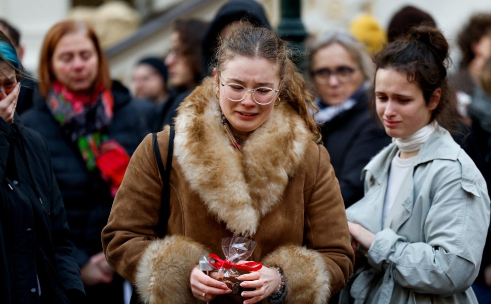 Άνθρωποι με λουλούδια στα χέρια φθάνουν στο σημείο του μακελειού στην Πράγα / Reuters