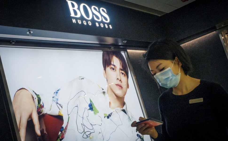 A woman walks past a store of German fashion house Hugo Boss in Beijing, China, March 27, 2021.  REUTERS/Thomas Peter